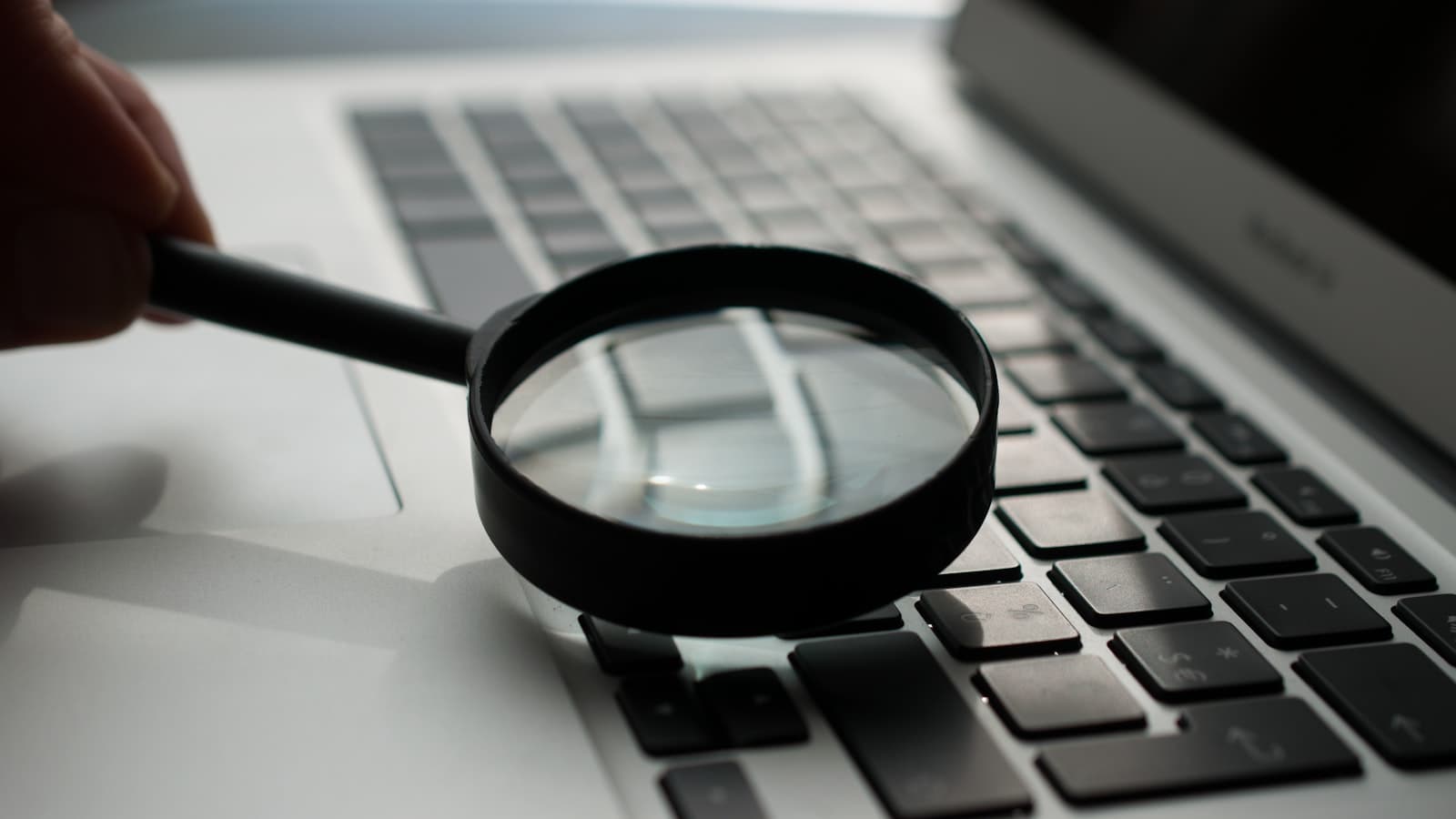 Magnifying glass over a screen — researching and analysing data